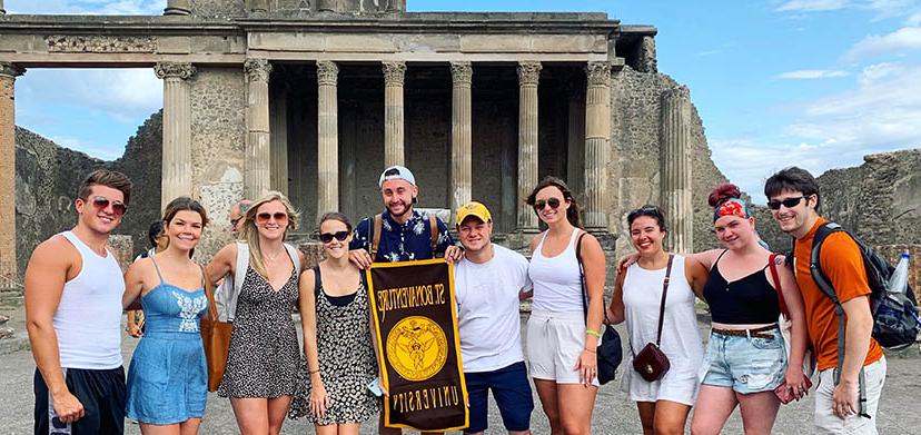 Sorrento program participants holding a Bonaventure banner on a visit to Pompeii